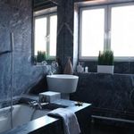 bathroom with a wealth of natural light, a bath, and sink