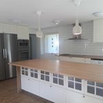kitchen featuring a center island, electric cooktop, stainless steel refrigerator, dishwasher, double oven, extractor fan, dark parquet floors, pendant lighting, light countertops, and white cabinets