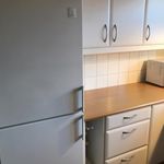 kök med kylskåp, vita skåp, lätta bänkskivor, och mörkt golv
