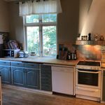 kitchen with natural light, microwave, electric range oven, dishwasher, ventilation hood, refrigerator, dark brown cabinets, light countertops, and light parquet floors