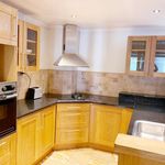kitchen with fume extractor, oven, dark countertops, light tile floors, and brown cabinets
