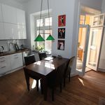 kitchen featuring natural light, microwave, radiator, white cabinets, dark hardwood flooring, pendant lighting, and dark countertops