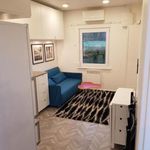 bedroom with refrigerator, radiator, and a wall mounted air conditioner