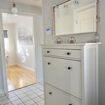 kitchen featuring light hardwood floors, white cabinets, light countertops, and pendant lighting