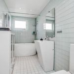 badrum med klinkergolv, naturligt ljus, kombinerat bad / dusch, spegel, och toalett