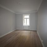 empty room featuring hardwood floors, natural light, and radiator