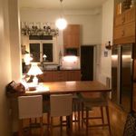 kök med rostfritt stå, parkettgolv, köksbar, kylskåp, taklampa, mörkt golv, och bruna skåp
