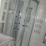 badrum med dusch, duschdörr, och sminkbord