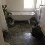 bathroom with natural light, tile floors, and a bathing tub
