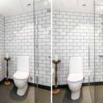 bathroom featuring sink, toilet, shower door, and mirror