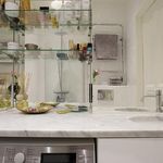 badrum med mikrovågsugn, spegel, sminkbord, och dubbel handfat