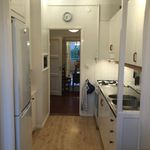 kök med parkettgolv, kylskåp, lätta bänkskivor, lätt golv, och vita skåp