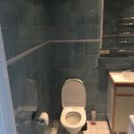 half bath with tile floors, toilet, mirror, and vanity with extensive cabinet space