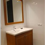 badrum med klinkergolv, spegel, sminkbord, och handfat