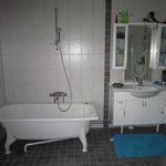 badrum med klinkergolv, kombinerat bad / dusch, bad, handfat, spegel, och sminkbord