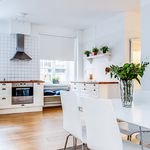 kök med rostfritt stå, parkettgolv, köksfläkt, ugn, taklampa, vita skåp, och lätt golv