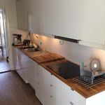 kitchen with dark countertops, dark hardwood flooring, and white cabinets