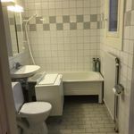 badrum med klinkergolv, spegel, kombinerat bad / dusch, och toalett