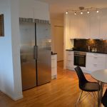 kök med rostfritt stå, parkettgolv, kylskåp, ugn, mörka bänkskivor, vita skåp, och lätt golv