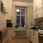 kök med parkettgolv, naturligt ljus, ugn, radiator, mörka bänkskivor, lätt golv, och vita skåp
