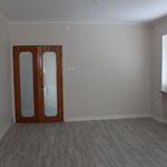 empty room featuring natural light, french doors, hardwood flooring, and radiator