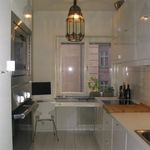 kök med klinkergolv, mikrovågsugn, radiator, elektrisk spishäll, tv, ugn, lätta bänkskivor, taklampa, vita skåp, och lätt golv