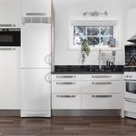 kitchen with natural light, range oven, range hood, oven, dark hardwood floors, dark countertops, and white cabinetry