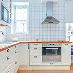 kök med rostfritt stå, parkettgolv, naturligt ljus, ugn, köksfläkt, lätta bänkskivor, vita skåp, och lätt golv