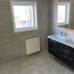 badrum med klinkergolv, naturligt ljus, radiator, spegel, dubbel handfat, och sminkbord