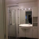 badrum med klinkergolv, spegel, sminkbord, dusch, och handfat