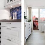 kök med parkettgolv, naturligt ljus, vita skåp, och lätt golv
