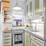 kitchen with refrigerator, range oven, white cabinets, light stone countertops, pendant lighting, and light parquet floors