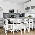 kök med rostfritt stå, parkettgolv, naturligt ljus, kylskåp, mikrovågsugn, vita skåp, och lätt golv
