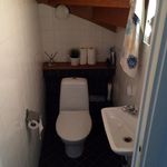 badrum med klinkergolv, toalett, och handfat