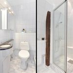 badrum med spegel, duschdörr, dusch, och toalett