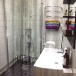 badrum med dusch, duschdörr, handfat, spegel, och sminkbord
