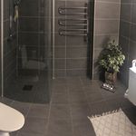 bathroom featuring tile floors, toilet, and shower door